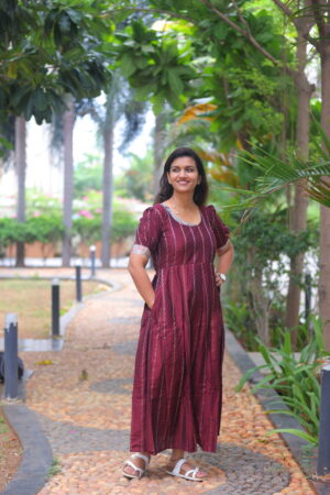 Woman wearing maroon silk cotton maternity maxi dress with puff sleeves, Aayizhai Fashions.